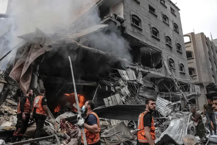 104618916-palestinian-firefighters-battle-a-blaze-after-an-israeli-airstrike-on-buildings-in-the-ref